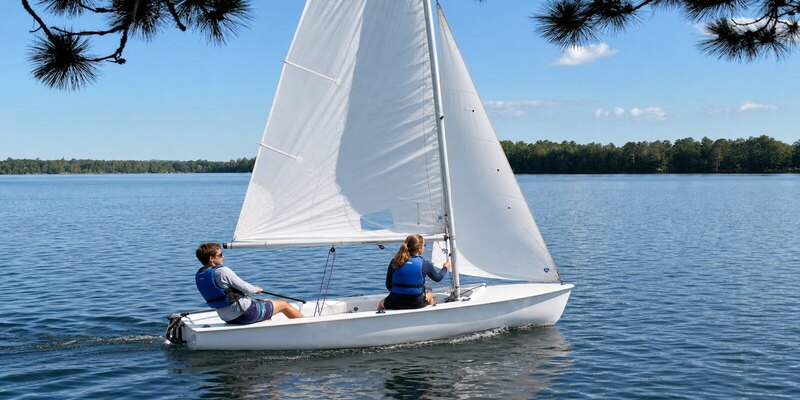 Two sailors handling the main and jib of a Club 420 on Farallon Cove