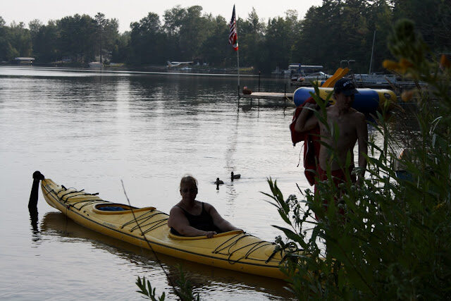 A paddler in a yellow kayak getting dockside pointers before heading out