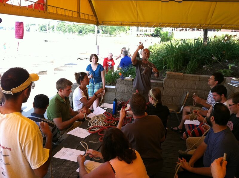 A Learn to Sail class practicing knots around the dockside picnic table