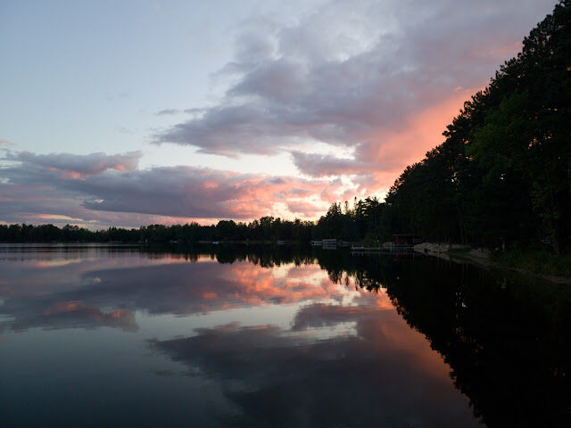 A coral sunset over the lake, docks silhouetted along the shore